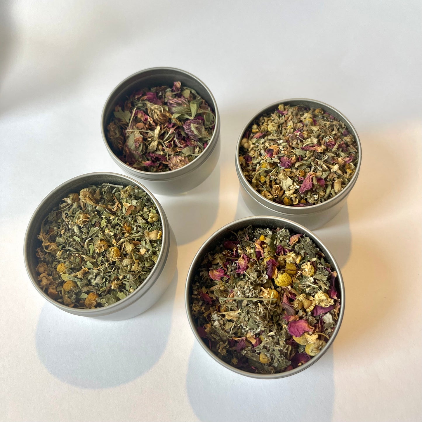 4 tins containing a mix of herbal tea: roots, berries and flowers