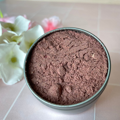 powder herbs in metal tin on tile counter next to flowers